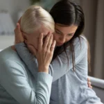 Old woman and daughter hugging while woman is crying
